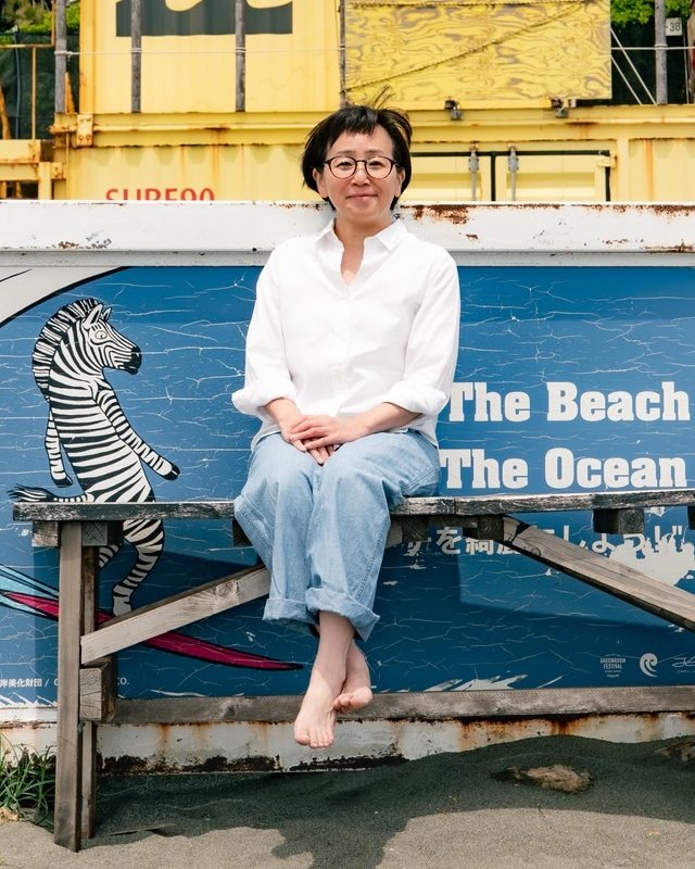 海辺のベンチに座る村野 美加子さん
